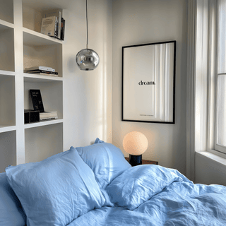 Personalised Quote Poster print on a wall in a bedroom with blue bedding and a round lamp