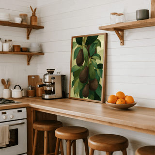 Print leaning on kitchen counter of hanging green and dark avocados with leaves beside a wooden bowl of oranges