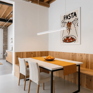 Pasta Art Print on a dining room wall with orange table runner and wooden chairs