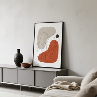 Simple Abstract Art print leaning on a grey sideboard with a black vase and bowl nearby