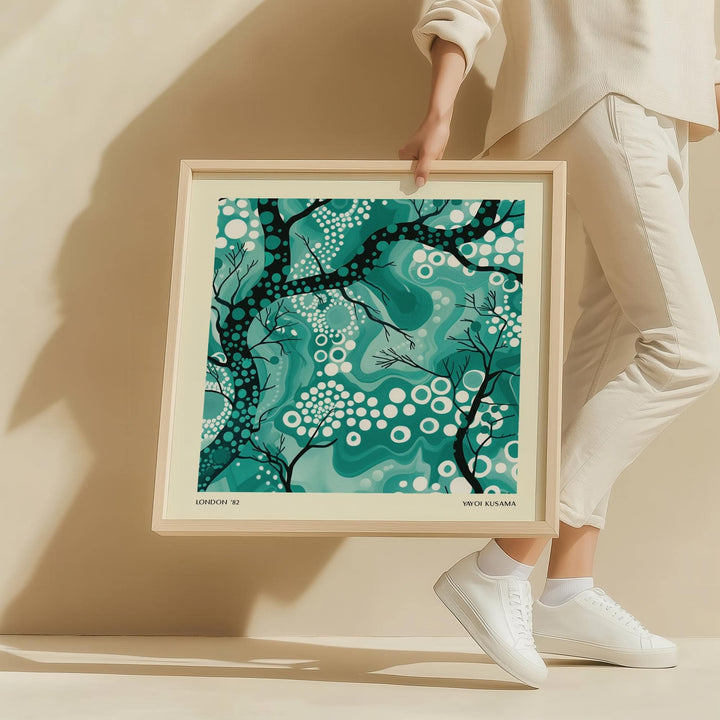 Teal Abstract Wall Art of abstract tree branches in shades of green and black held by a person