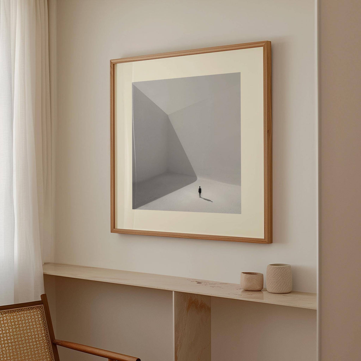 Square art prints photographic minimalist grey and white artwork above a shelf with small pottery in a pale room