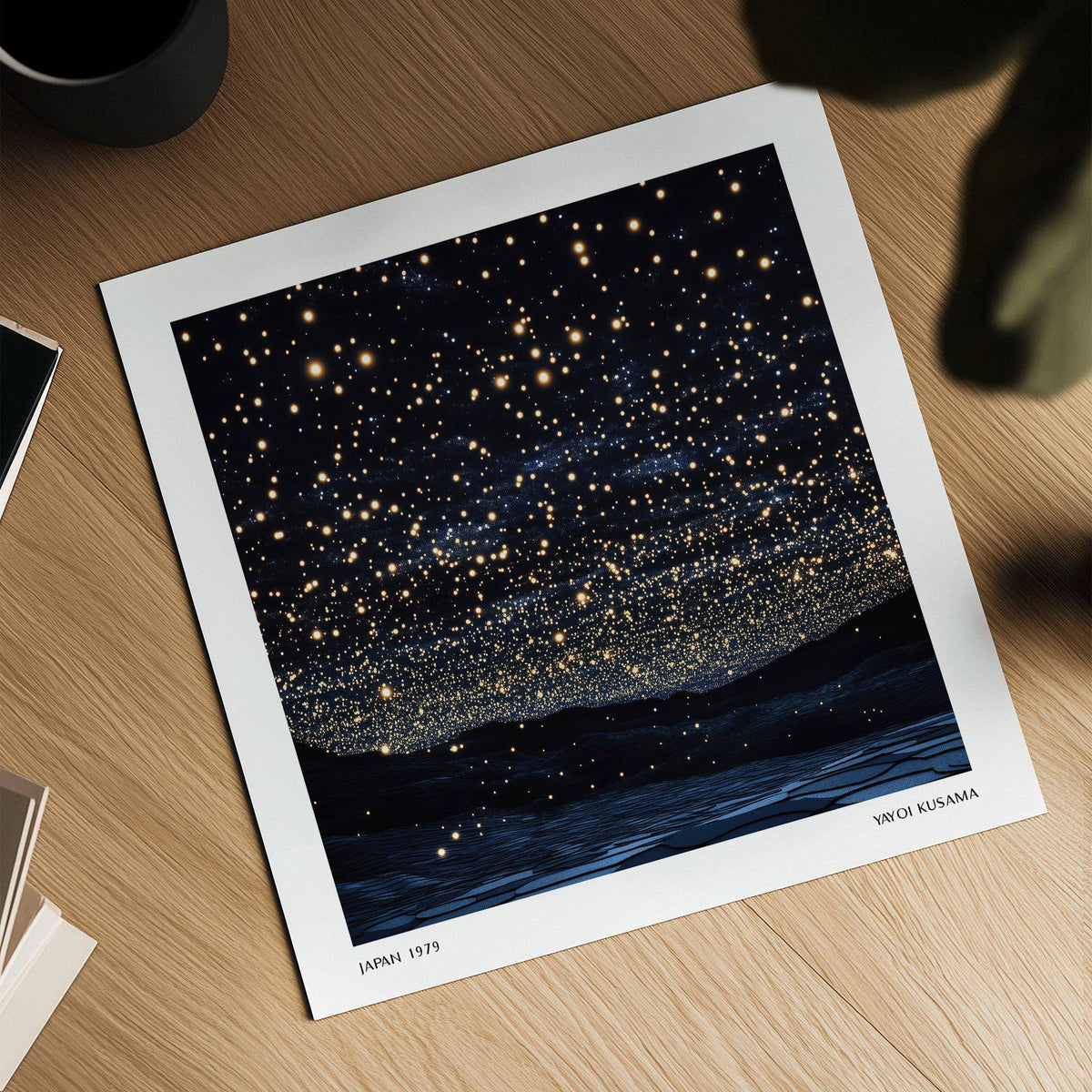 Starry Night Print lying on a wooden surface with a cup and some books nearby