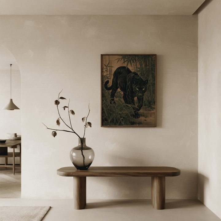 Print on a wall of a black panther in a bamboo jungle with green and brown tones above a wooden table