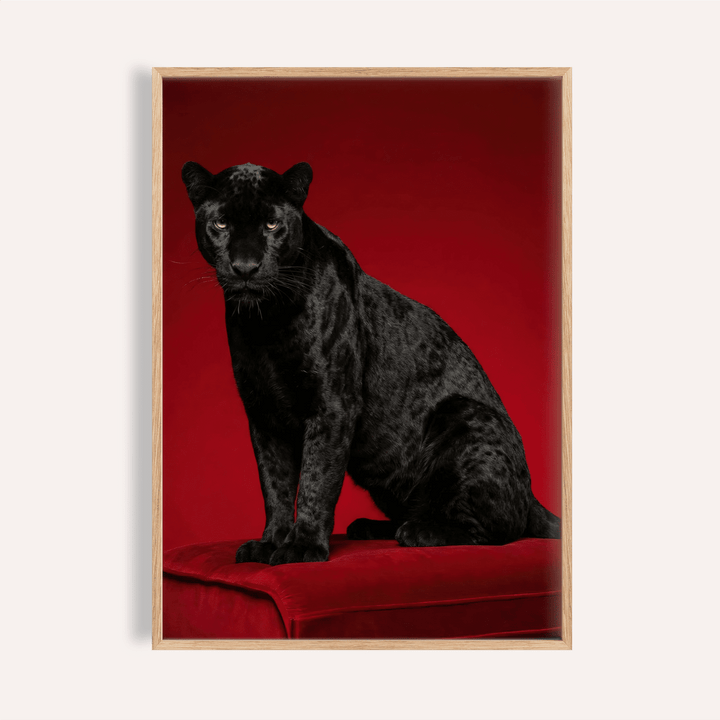 Close-up of black panther art print showing glossy black fur and red background with wooden frame