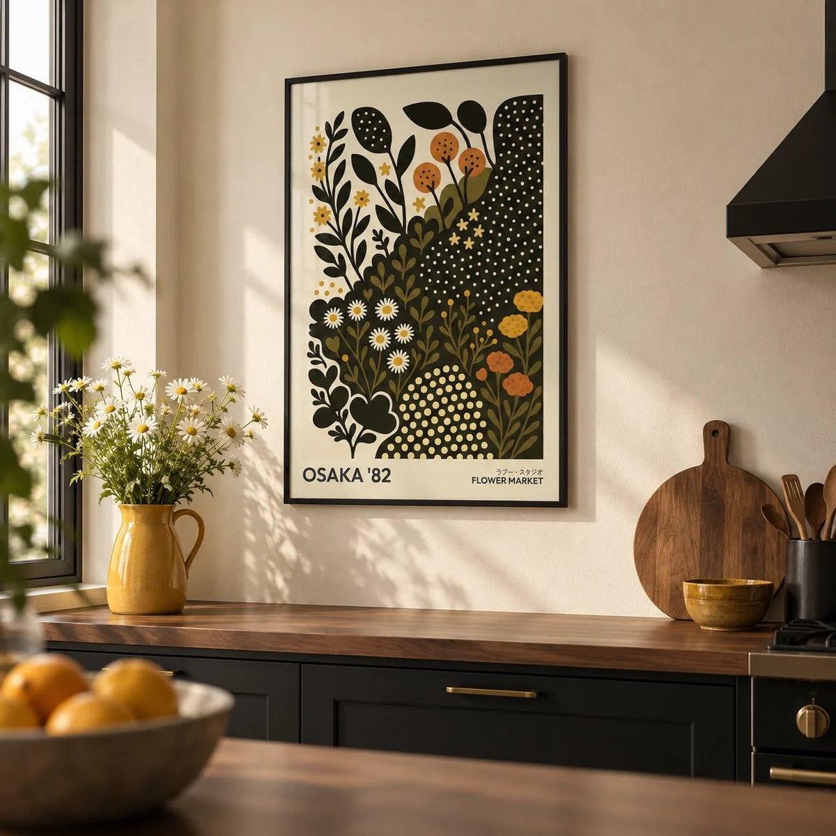 Daisy Art Print, framed on the wall of a modern kitchen with solid black painted cabinets and a warm cream plaster wall