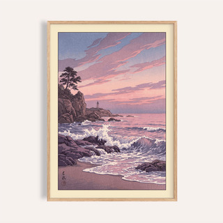Framed print of a rocky coastline with waves and lighthouse at sunset in pink and purple hues