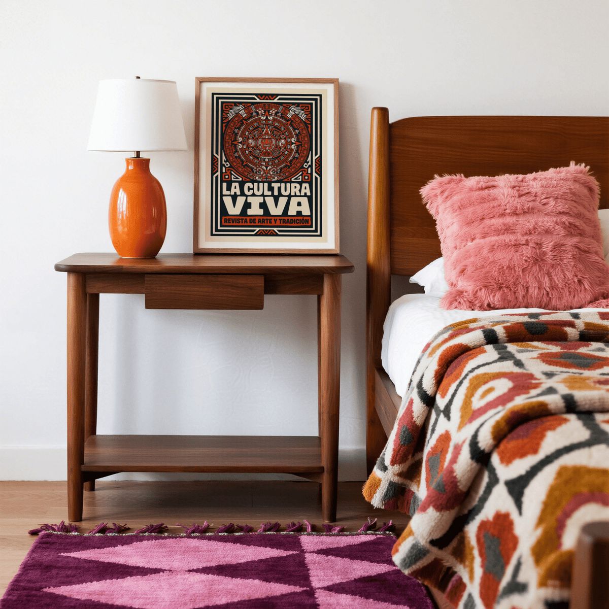 Framed Aztec Culture Art Print on a wooden bedside table with an orange lamp in a bedroom