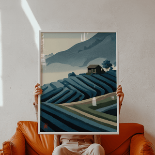 Framed close-up of rice paddy wall art showing blue and green mountain tea plantation held over a brown leather chair