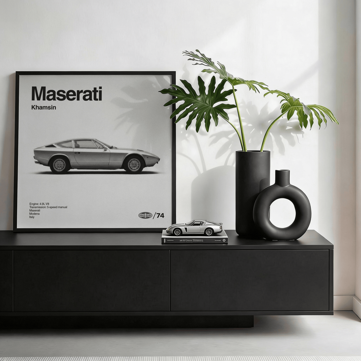 Classic 1970s Grand Tourer Poster leaning on a black sideboard with green plants in modern room