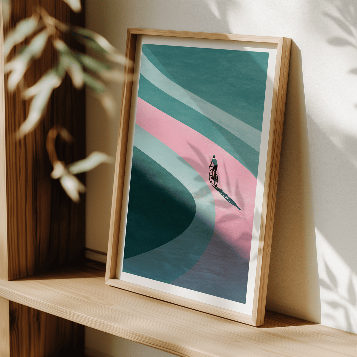 Minimalist Cycling Art Print leaning on a wooden shelf with light and shadows