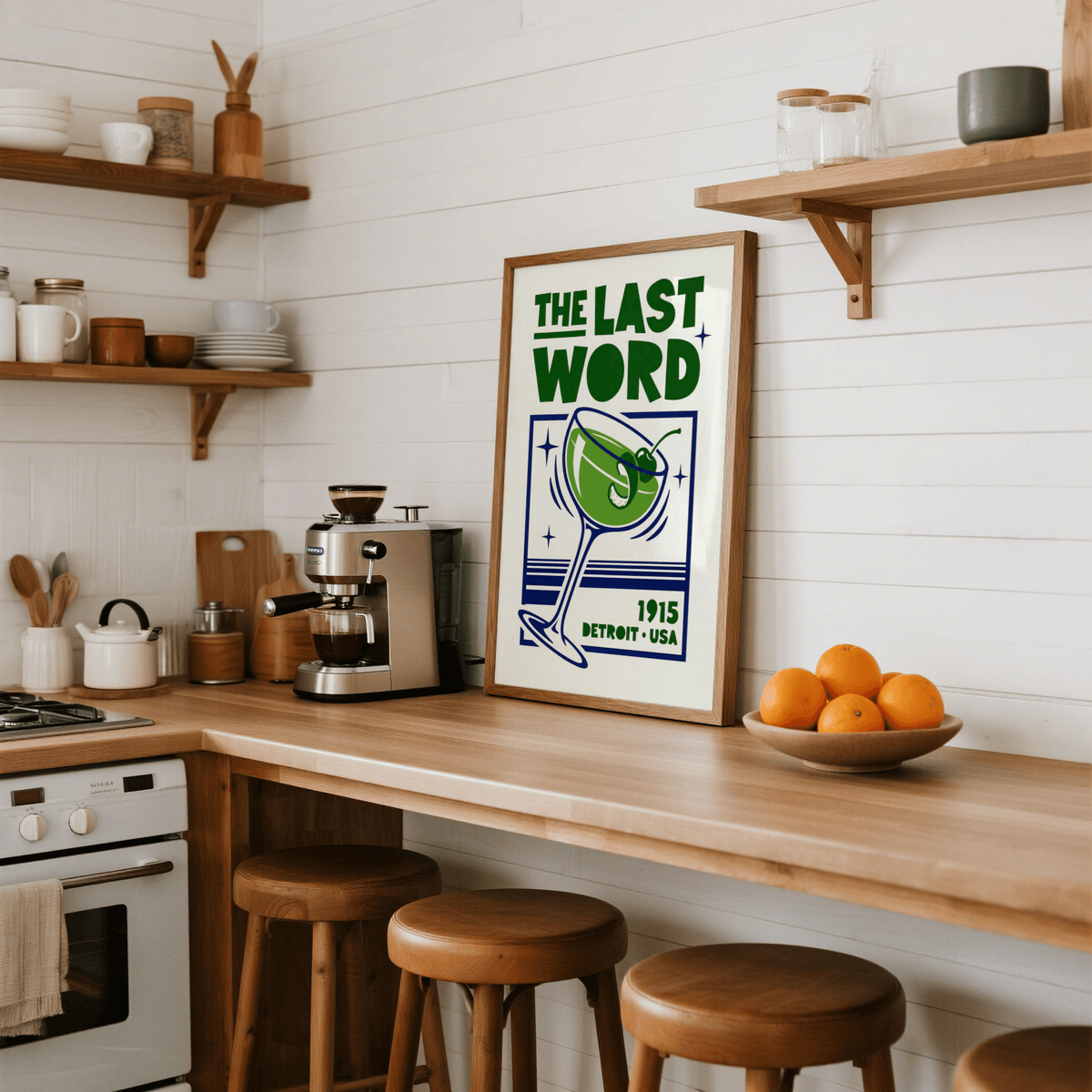 Cocktail Art Print leaning on a kitchen counter with wooden stools and a bowl of oranges