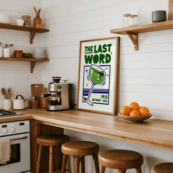 Cocktail Art Print leaning on a kitchen counter with wooden stools and a bowl of oranges