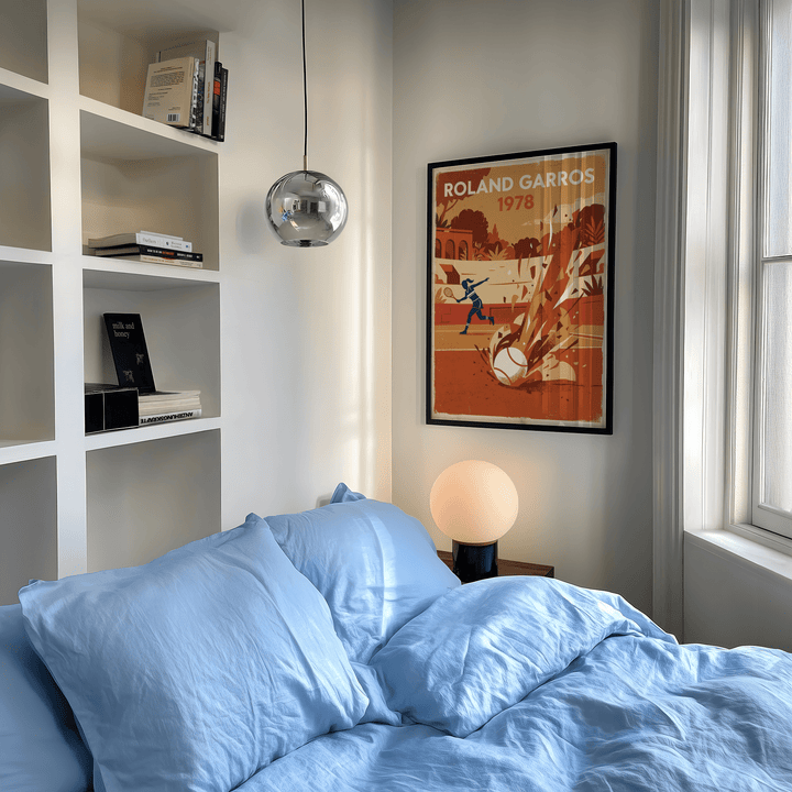 Vintage Tennis Art Print framed on a white wall above a bedside lamp in a bedroom