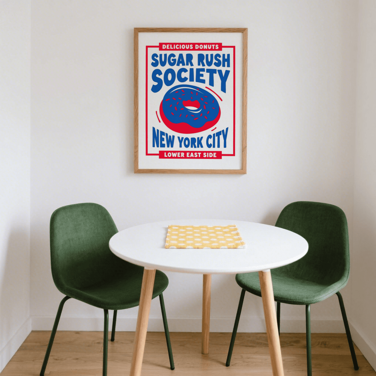 Donut wall art of a blue frosted donut with red sprinkles above a round table with green chairs