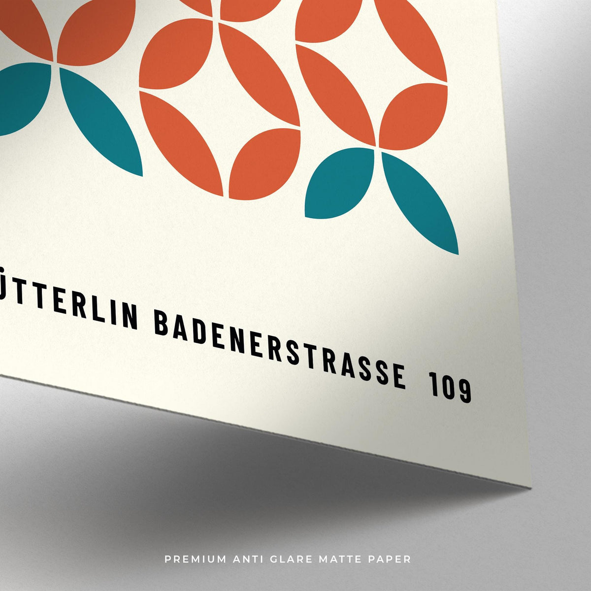 Detail close-up of modern geometric wall art showing abstract shapes in teal and orange on matte paper
