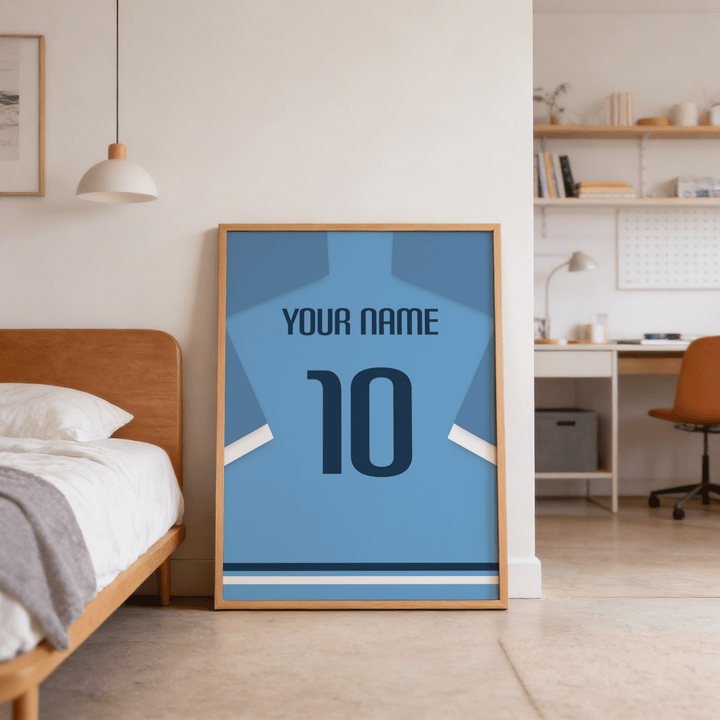 Football Shirt Poster in Light Blue with Dark Blue Number leaning against the wall near a wooden bed