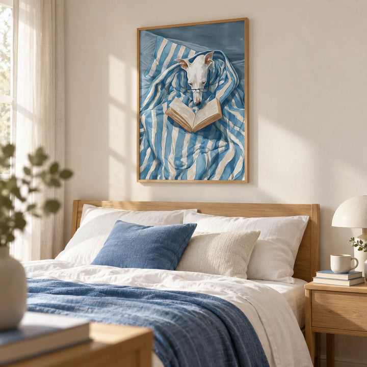 Dog Reading Print, framed on the wall of a cosy bedroom with a warm white wall