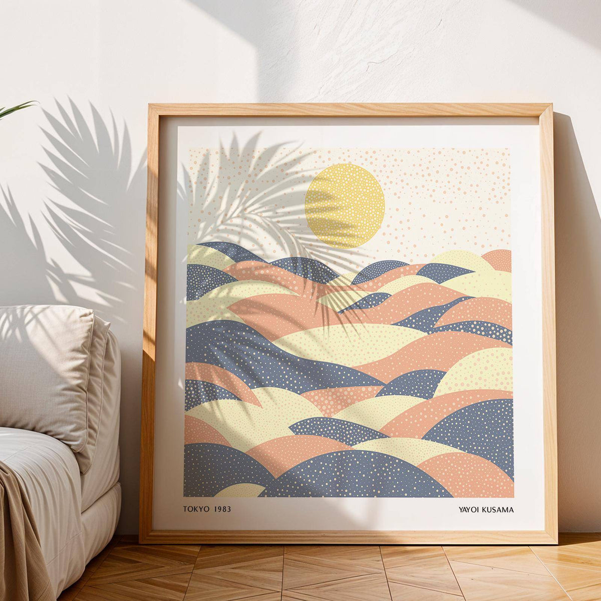 Framed Dream Hills pastel wall art with abstract hills and sun leaning against wall next to sofa and plant shadow