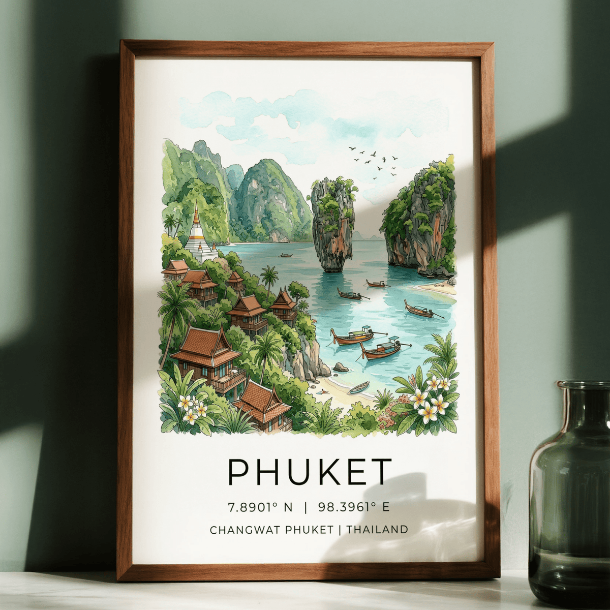 Framed Phuket art print with green watercolour beach bay scene and wooden frame next to glass vase