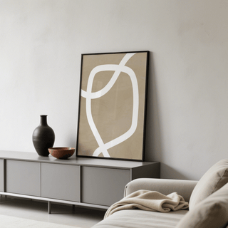Print leaning on a shelf featuring curved white line on beige in a minimalist style with a dark vase nearby