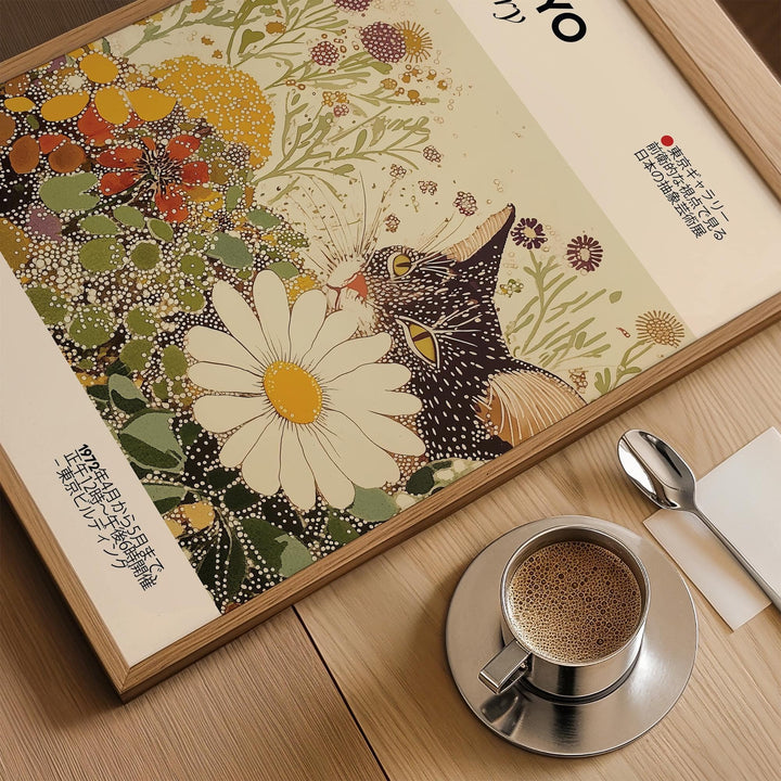 Framed close-up of vintage cat wall art showing a tuxedo cat with white and yellow flowers on a wooden table with a cup of coffee