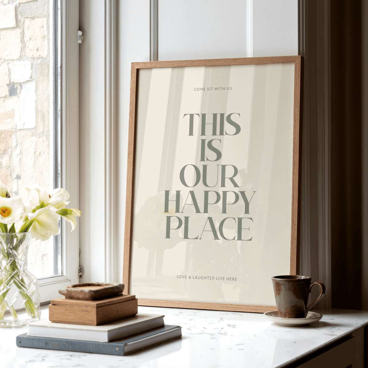 Inspirational wall sign leaning on a marble surface near window with flowers and mug