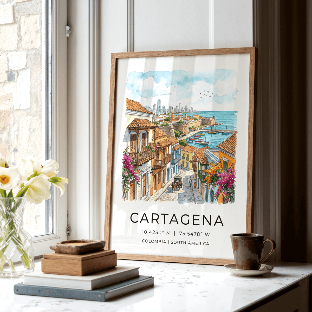 Framed Cartagena art print of city view in watercolour style leaning by window and cup
