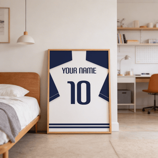 Print leaning on the floor of a bedroom showing a minimalist football shirt poster in white with navy sleeves and navy number