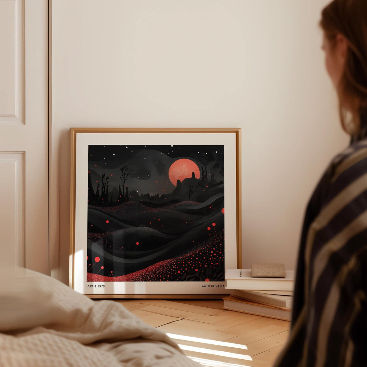 Wall Moon Art print leaning on the floor by a book stack in soft daylight