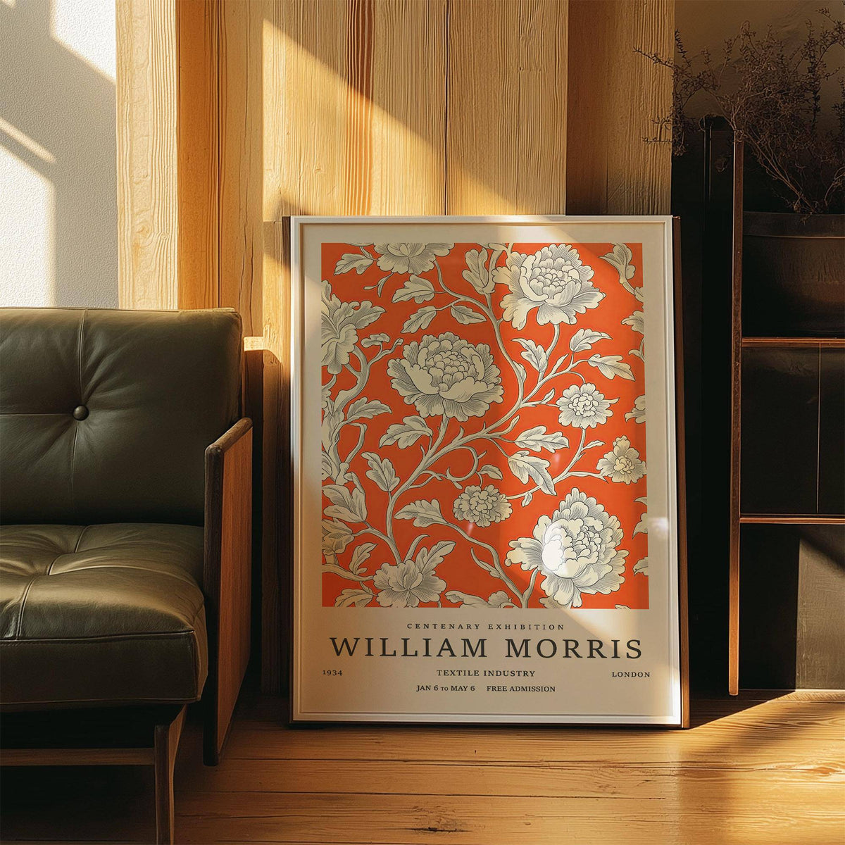 Vintage Flower Art print leaning on a wooden floor beside a green leather chair with sunlight falling on it