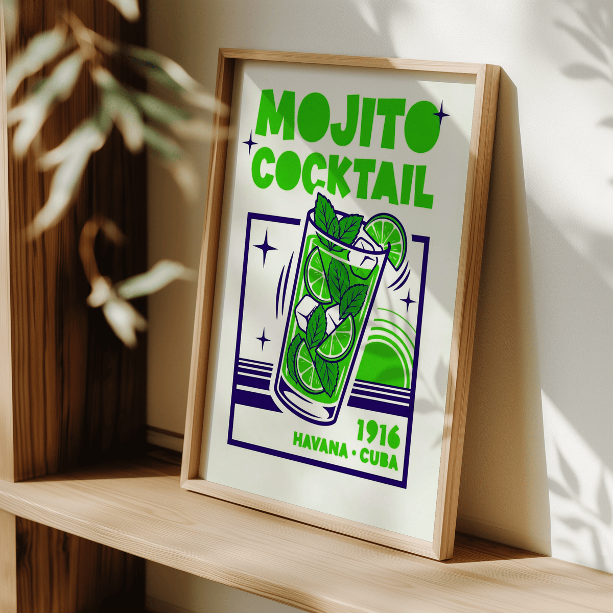 Framed Mojito Cocktail Print leaning on a wooden shelf with leafy shadows