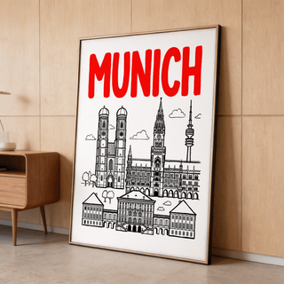 Print leaning on a floor of Munich city poster with red title and black line-art details near a wooden side table