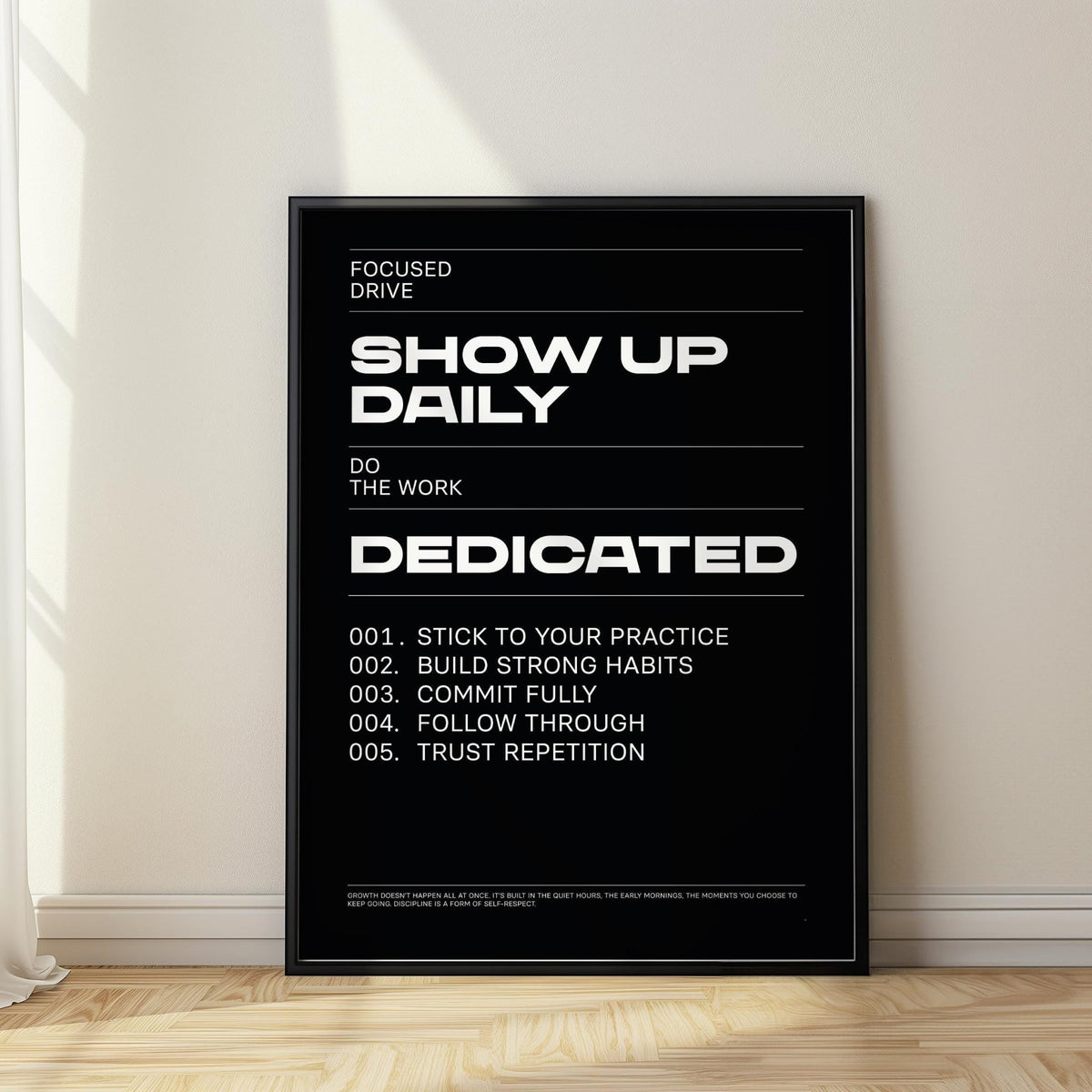 Wall Art Work motivational text poster with white type on black leaning on a wooden floor near a curtain