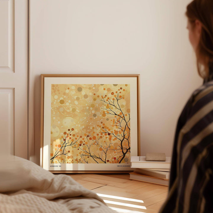 Family Room Wall Decor print leaning on the floor with warm golden branches and berries near books
