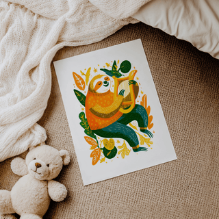 Sloth art print of a sloth playing a harp in orange and green tones lying on a textured carpet near a teddy bear and blanket