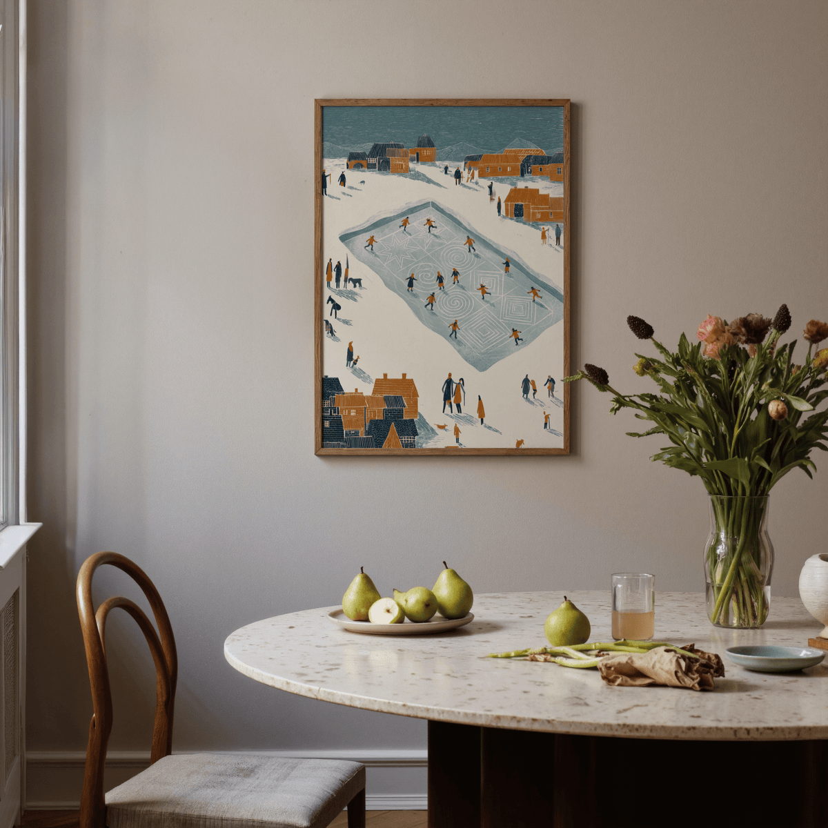 Ice Skating Poster on a dining room wall above a round marble table with fruit and a vase