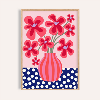 Framed Colorful Flower Poster with red stylised flowers in a pink and blue vase on a polka dot table