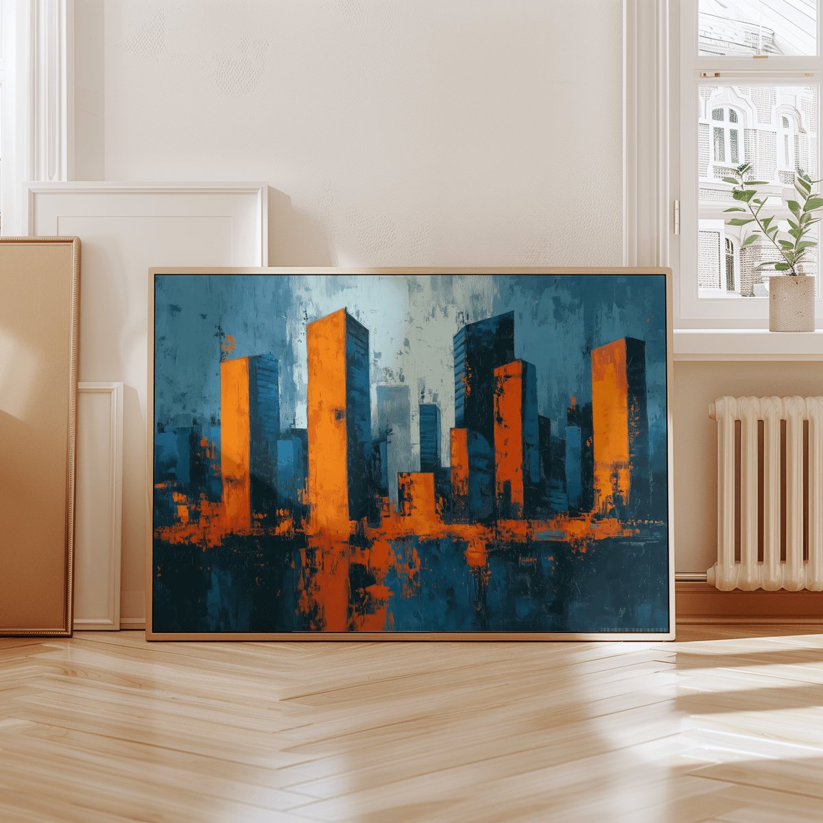 Print leaning on a floor showing cityscape wall art with abstract orange and blue skyline in a bright room