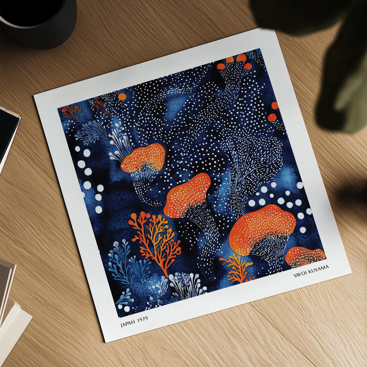 Abstract floral art showing orange mushrooms and white dots on a deep blue background on a wooden surface with a plant