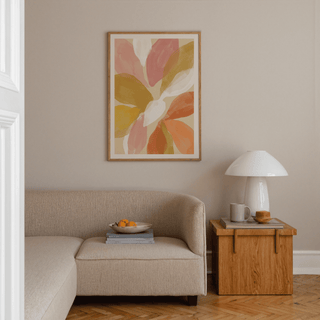 Floral Watercolor Art Print featuring abstract flower petals in pink, mustard and orange above a beige sofa