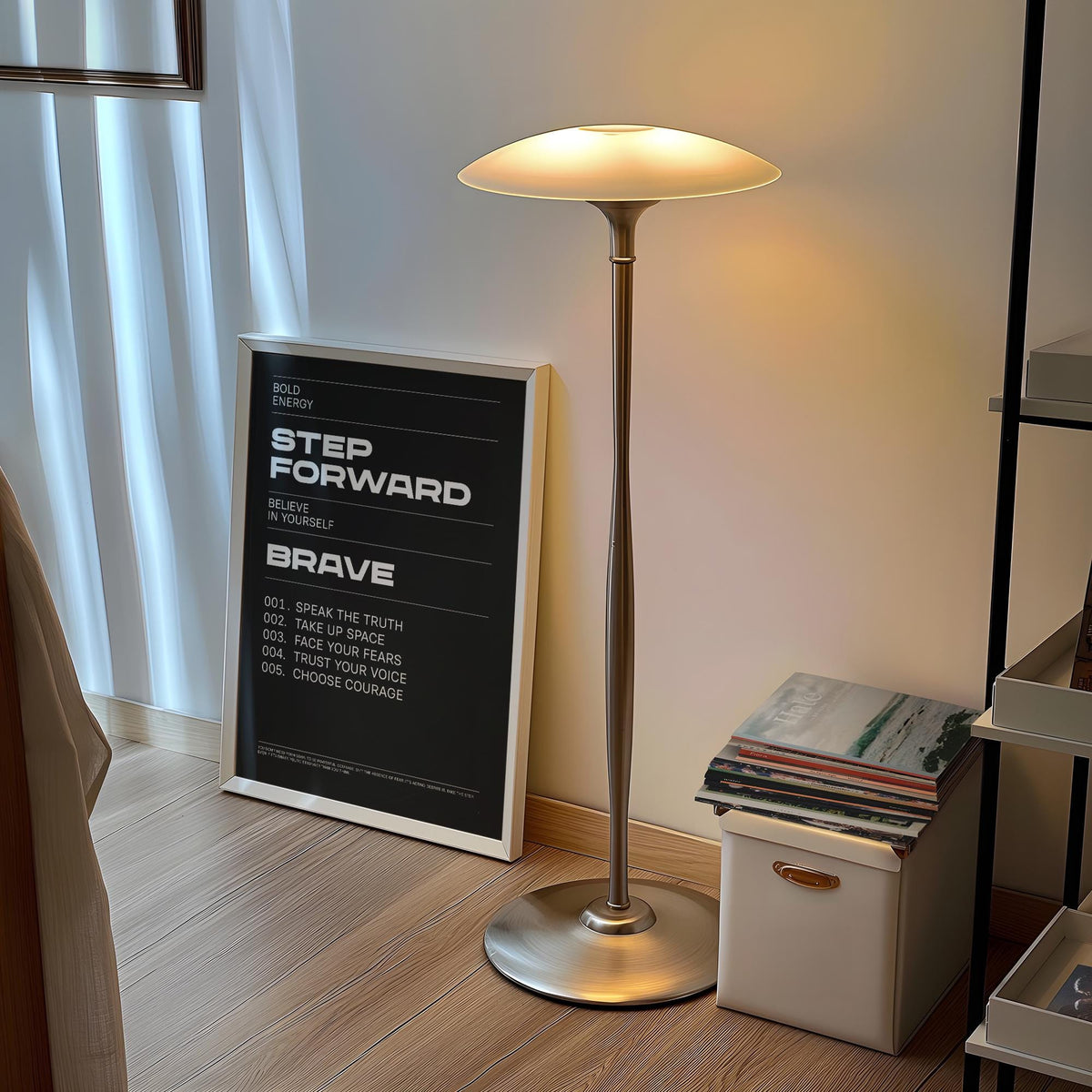 Print leaning on floor light wood floor motivational text in black and white with metal lamp nearby