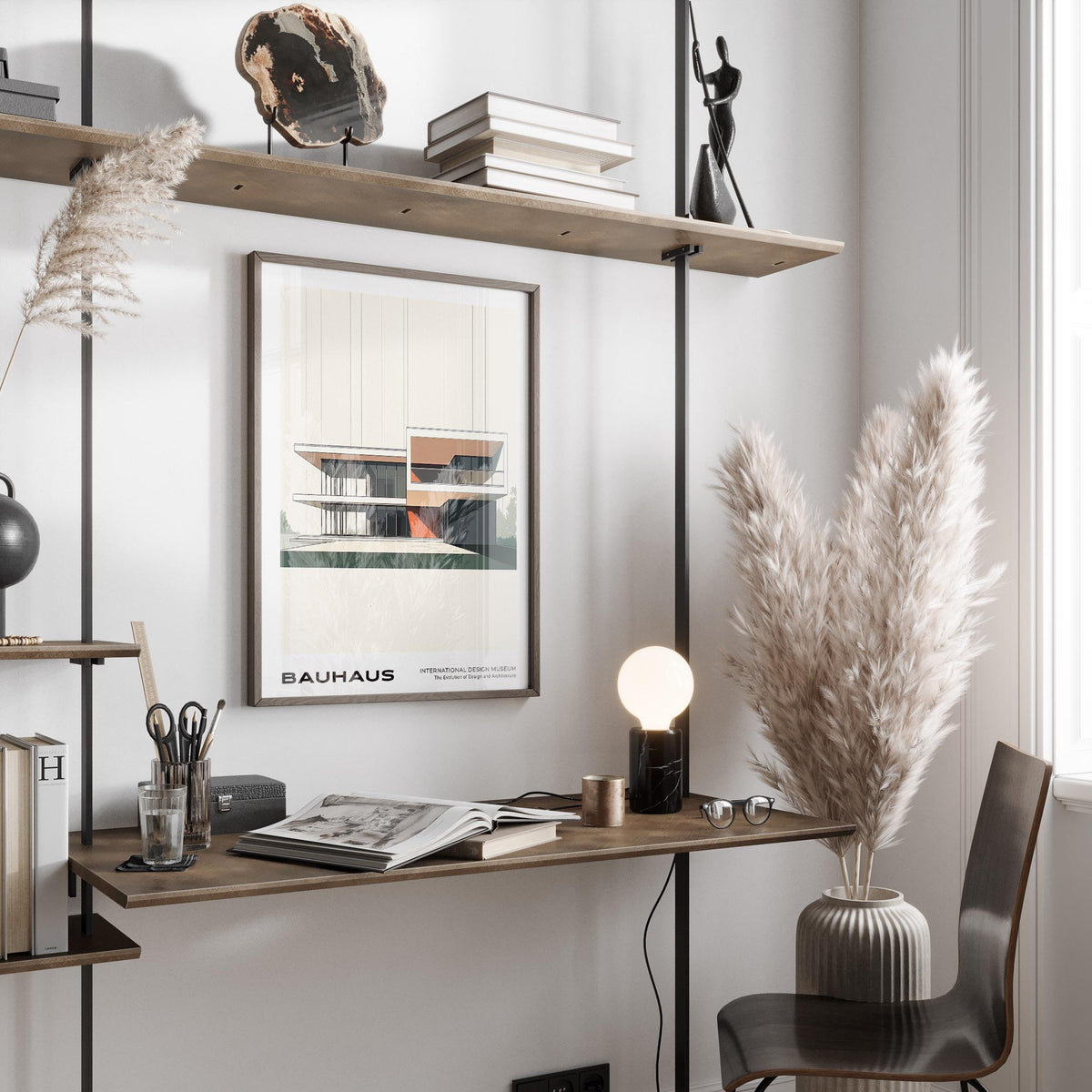 Framed Bauhaus Architecture Poster of a modernist building in neutral tones above a wooden desk with a lamp