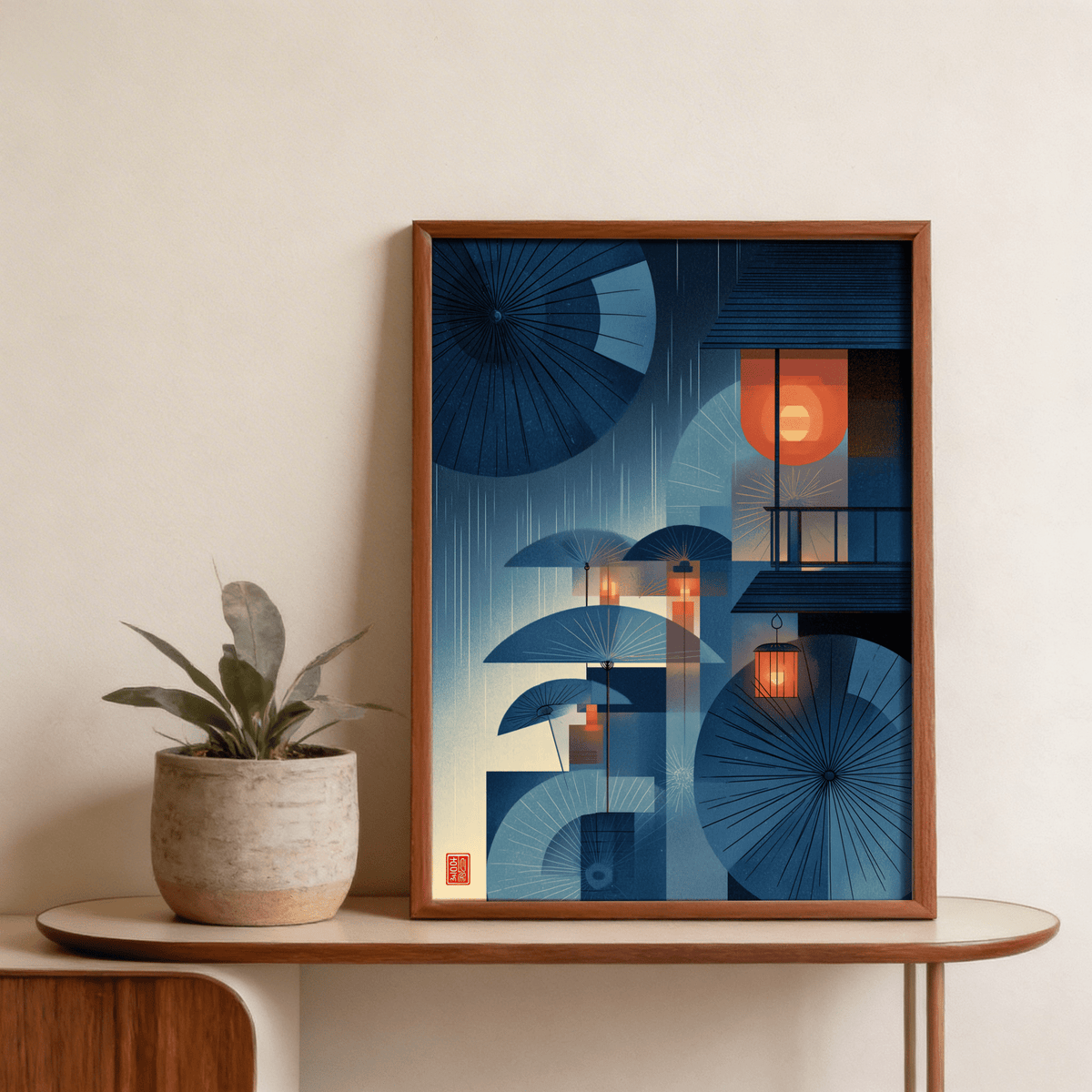 Framed Japanese Umbrella wall art showing blue oriental umbrellas and lanterns next to a potted plant
