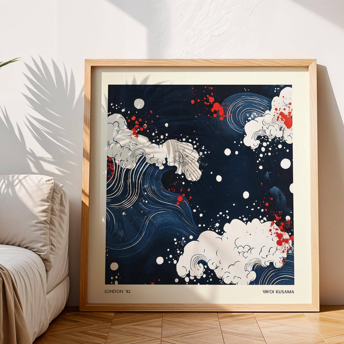 Japanese Art print leaning on floor with stylised white waves on dark blue and red splashes near a beige sofa