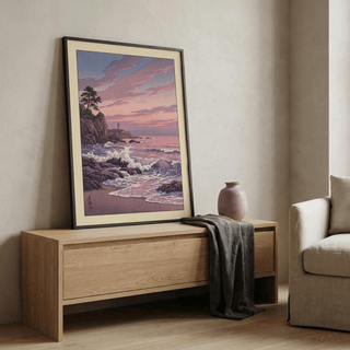 Lighthouse Sunset wall art leaning on a wooden sideboard with a ceramic vase and a grey cloth