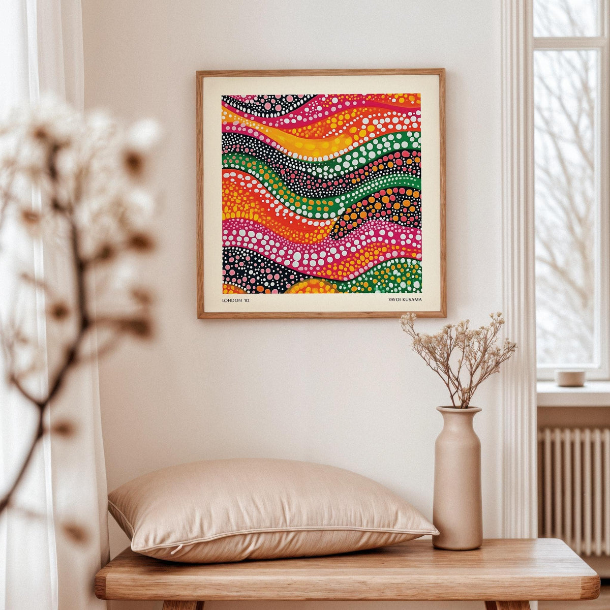Abstract Art Colorful framed print of colorful dotted waves above a wooden table with vase and cushion