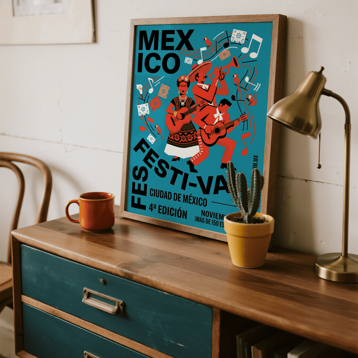Mexican Festivity Art Print leaning on a wooden dresser with a cactus and brass lamp nearby