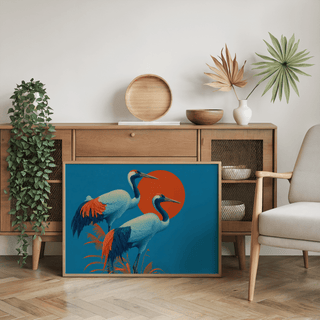 Print leaning on floor of cranes artwork showing pair of cranes in blue and orange colours above a wooden sideboard