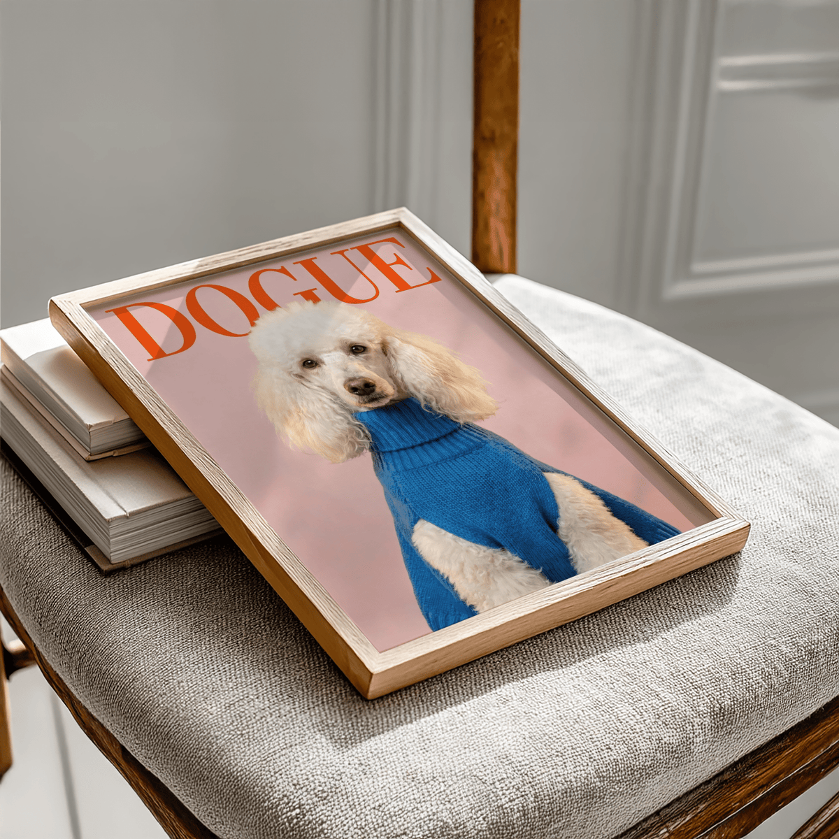 Framed Dogue Poodle Print of a white poodle in a blue sweater lying on a grey textured chair